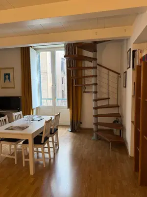 a dining room with a table and a spiral staircase at La casa delle stelle in Palermo