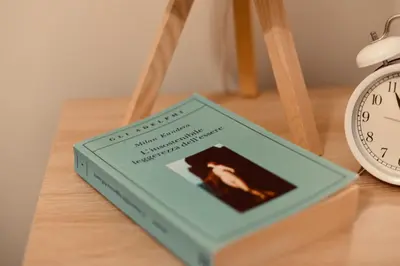 a book sitting on a table next to a clock at Dimora Beatrice in Termini Imerese