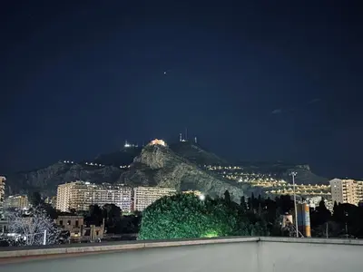 a view of a city at night with a mountain at Sampolo Rooftop - Palermo View in Palermo