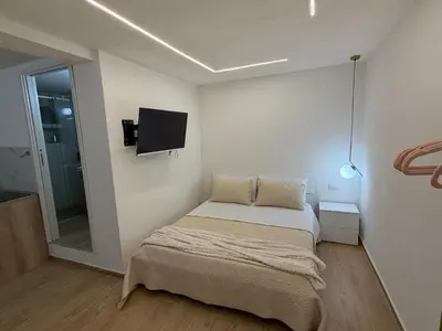 a bedroom with a bed and a tv on the wall at A casa del capo in Palermo