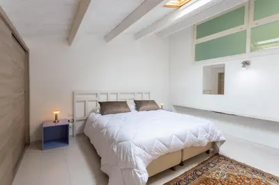an attic bedroom with a bed and a skylight at Hola House Politeama Theatre in Palermo