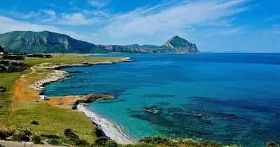 a view of a beach with mountains in the distance at Appartamento Calvino piano terra in via Mulino 31 in San Vito lo Capo