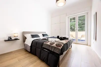 a white bedroom with a large bed and a window at A due passi dal mare in Palermo