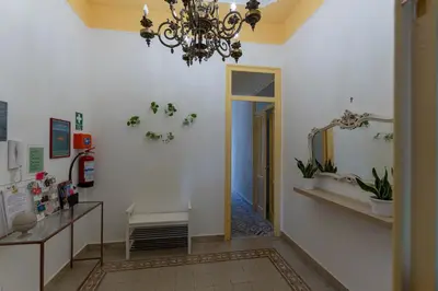 a hallway with a chandelier and a room with a mirror at Casa Botanica Apartment in Palermo