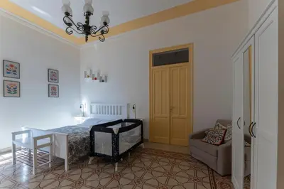 a bedroom with a bed and a table and a chair at Casa Botanica Apartment in Palermo
