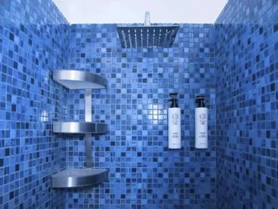 a blue tiled bathroom with two bottles of soap at Apartment Villa am Meer Trappeto by Interhome in Trappeto