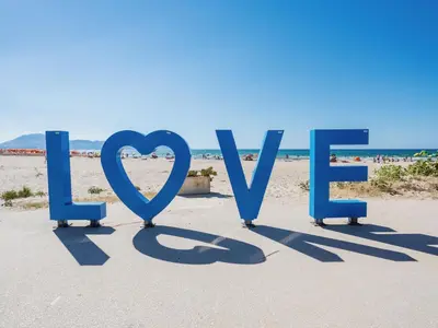 a sign that reads love on the beach at Apartment für 6 oder 7 Personen by Interhome in Balestrate