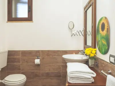 a bathroom with a sink and a toilet and a mirror at Apartment Wohnung GIallo mit Schwimmbad und Meerblick by Interhome in Balestrate