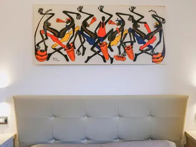 a painting hanging on a wall above a couch at Apartment Lila Wohnung mit Schwimmbad und Meerblick by Interhome in Balestrate