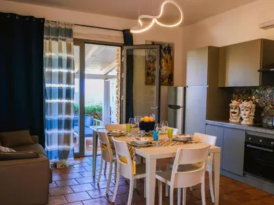 a kitchen and dining room with a table and chairs at Apartment Wohnung in Balestrate mit Schwimmbad und Meerblick by Interhome in Balestrate