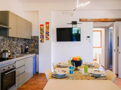 a kitchen with a table with chairs and a dining room at Apartment Wohnung in Balestrate mit Schwimmbad und Meerblick by Interhome in Balestrate