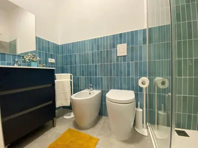a blue tiled bathroom with a toilet and a sink at Apartment Casa La Mamà- Strand 150 m entfernt by Interhome in Alcamo