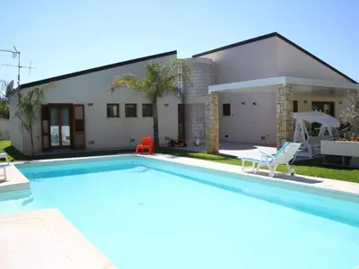 a swimming pool in front of a house at Holiday Home Villa in Sizilien am Meer mit beheiztem Pool by Interhome in Alcamo Marina