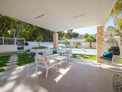 an outdoor patio with white chairs and a table at Holiday Home Villa in Sizilien am Meer mit beheiztem Pool by Interhome in Alcamo Marina