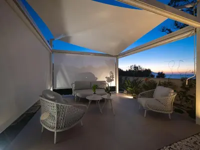 a screened in porch with chairs and a table at Holiday Home Villa in Sizilien am Meer mit beheiztem Pool by Interhome in Alcamo Marina