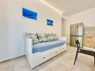 a white bedroom with a bed and a refrigerator at Apartment Sea Life Giulia- 200 m vom Strand entfernt by Interhome in Alcamo Marina