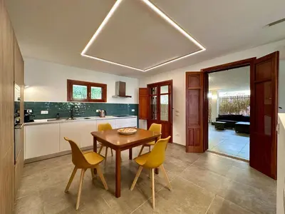 a kitchen with a wooden table and yellow chairs at Apartment Villa Sao- Scopello- Punta Pispisa by Interhome in Scopello