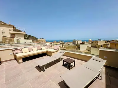 a balcony with a couch and chairs on a roof at Apartment GS Urlaub del Golfo Haus mit Jacuzzi by Interhome in Castellammare del Golfo