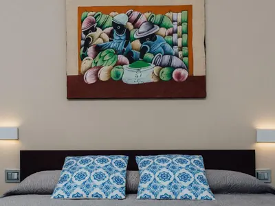 a bedroom with a painting on the wall above a bed at Holiday Home Haus in Balestrate mit privatem Parkplatz by Interhome in Balestrate