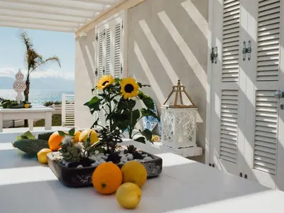 a table with a vase of oranges and flowers on it at Holiday Home Haus in Balestrate mit privatem Parkplatz by Interhome in Balestrate