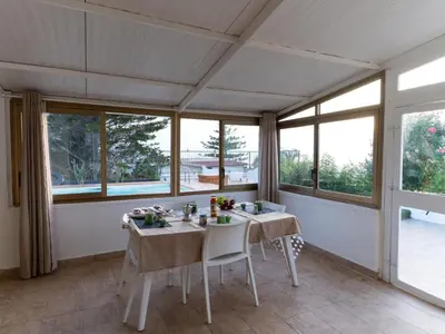 a dining room with two tables and windows at Holiday Home Villa Panorama del Golfo mit privatem Pool und Grillplatz by Interhome in Balestrate