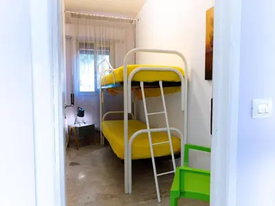 a room with two bunk beds and a yellow chair at Holiday Home Villa Panorama del Golfo mit privatem Pool und Grillplatz by Interhome in Balestrate