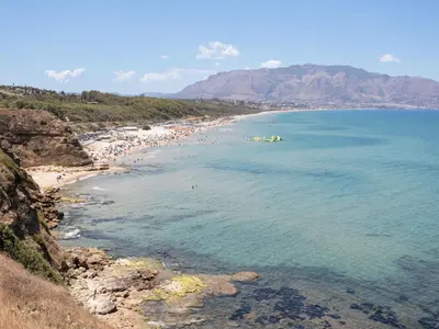 a beach with a bunch of people in the water at Holiday Home Villa Panorama del Golfo mit privatem Pool und Grillplatz by Interhome in Balestrate