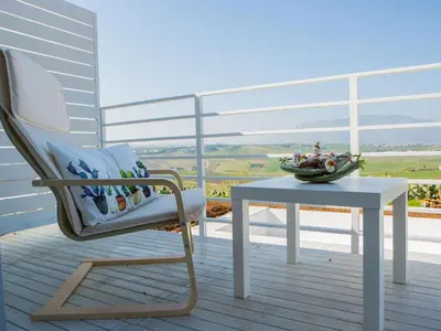 a rocking chair and a table on a balcony at Holiday Home in Partinico mit Privatem Pool by Interhome in Balestrate