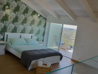 a bedroom with a large bed and a balcony at Holiday Home in Partinico mit Privatem Pool by Interhome in Balestrate