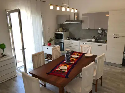a kitchen and dining room with a table and chairs at Holiday Home Villa Oasi- 50 m vom Strand entfernt- klimatisiert by Interhome in Alcamo