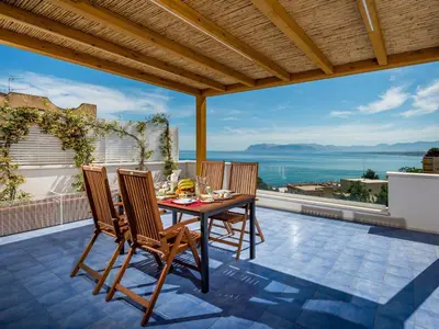a table and chairs on a patio with a view at Apartment BluOltremare-Terrasse by Interhome in Castellammare del Golfo
