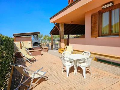 a patio with a table and chairs and a grill at Holiday Home Villa mit Wasserblick by Interhome in Campofelice di Roccella