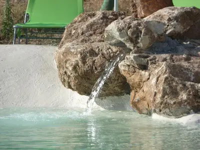 a water fountain in a pool with a large rock at Holiday Home 'Suite Zibibbo' mit Aussicht by Interhome in Santa Flavia