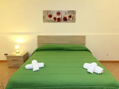 a bedroom with a green bed with two white pillows at Holiday Home Ferienvilla mit Wasserblick by Interhome in Campofelice di Roccella