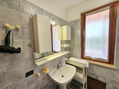 a bathroom with a sink and a mirror and a window at Holiday Home Villa mit Wasserblick by Interhome in Campofelice di Roccella