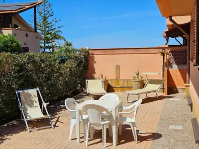 a patio with a table and chairs on a brick patio at Holiday Home Villa mit Wasserblick by Interhome in Campofelice di Roccella