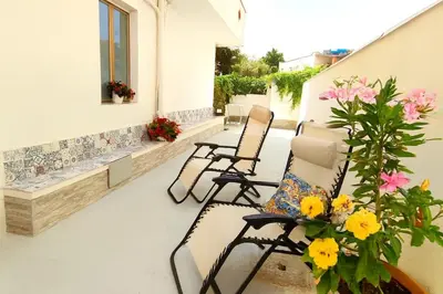 a room with a table and chairs and flowers at Per Famiglie ed Amici a 3 minuti a piedi dal mare Rosso Corallo Alcamo Marina in Alcamo Marina