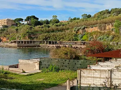 a body of water with a building on a hill at Fabian Appartament in Bagheria