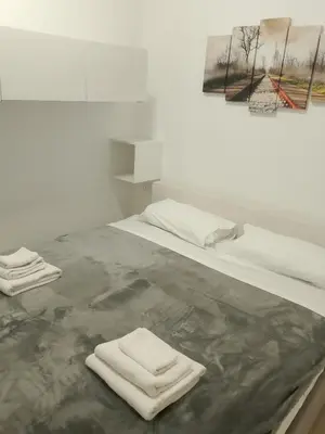 a white room with two white towels on a bed at Fabian Appartament in Bagheria