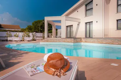 a hat sitting on a table next to a swimming pool at Gelso Bianco Collection Apartments in Campofelice di Roccella