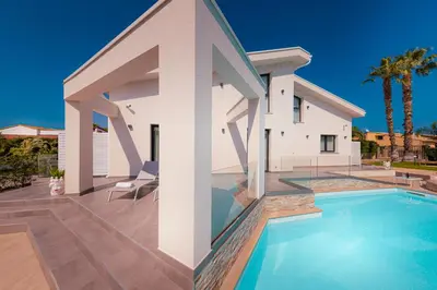 a house with a swimming pool in front of it at Gelso Bianco Collection Apartments in Campofelice di Roccella