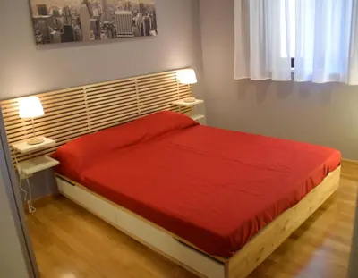 a bedroom with a red bed with two night stands at New Palermo Holidays Penelope in Mondello