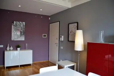 a living room with purple walls and a table and a lamp at New Palermo Holidays Penelope in Mondello