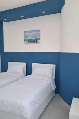 a bedroom with two beds and a picture of a car at Al ventitré Home in Trabia