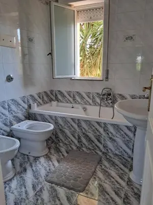 a bathroom with a tub and a toilet and a sink at Al ventitré Home in Trabia