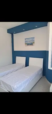 two beds in a bedroom with a blue wall at Al ventitré Home in Trabia