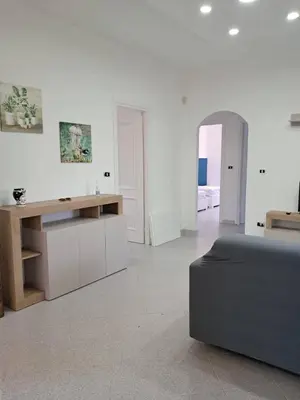 a white living room with a couch and a table at Al ventitré Home in Trabia