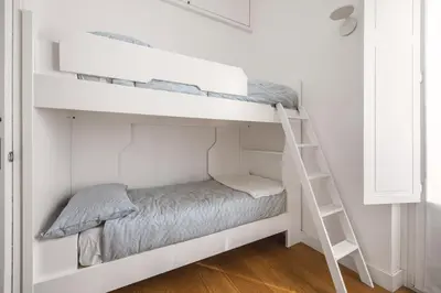 a bunk bed in a white room with a ladder at Giada's House By DomuSicily in Palermo