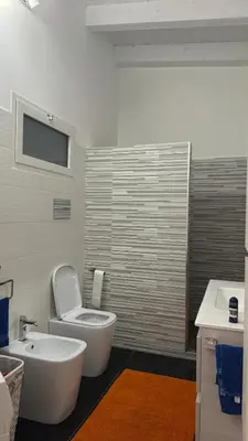 a bathroom with a white toilet and a sink at Brezza Marina apartment in Carini