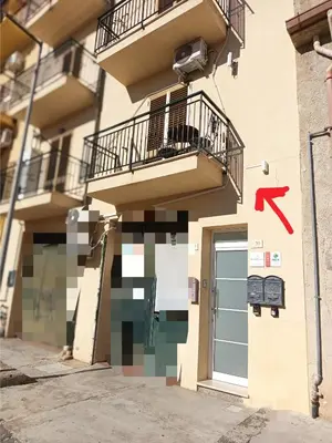 a building with a door with a red arrow at Profumo di casa 2 in Lascari